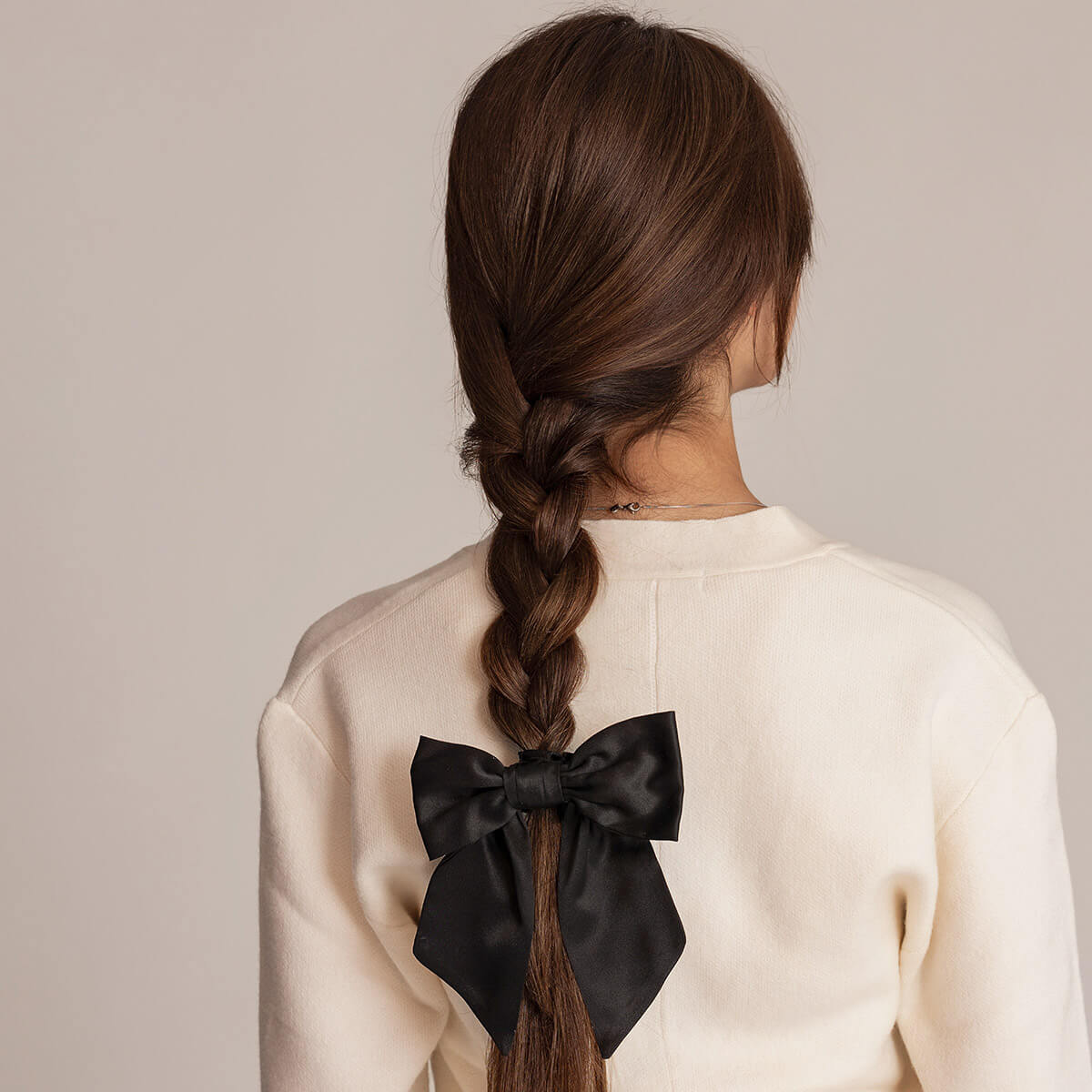 siden rosett med scrunchie i mörkt hår, för att undvika brutna hårstrån och ge en fin frisyr